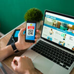 young man using discount coupon his smartphone some online shopping laptop